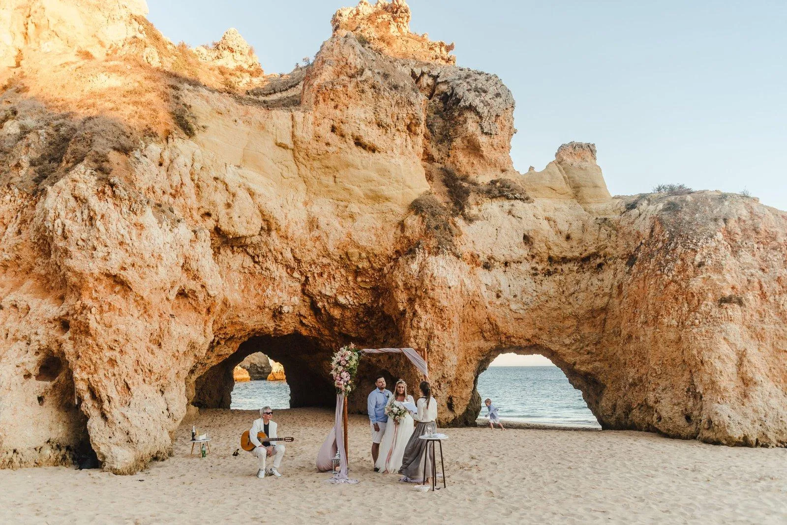 Garden ceremony framed by pine trees with the Atlantic behind the aisle of white petals